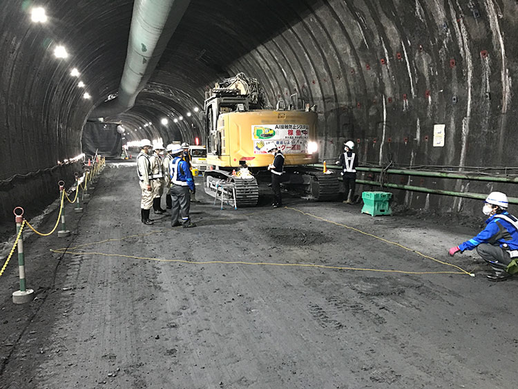 トンネル現場内で作業中の水口氏（中央）