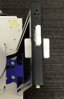 清水建設版エーアイスーツケース四号機のハンドルの写真。ハンドル上には前方に操作のための小さいボタンが四つ、ハンドルの上の面と左右の側面には振動ロータを搭載しています