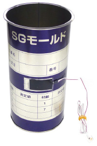 「SGモールド」この中にコンクリートを入れると缶ごと膨張する、そのひずみを測定することで膨張性能を把握することができる