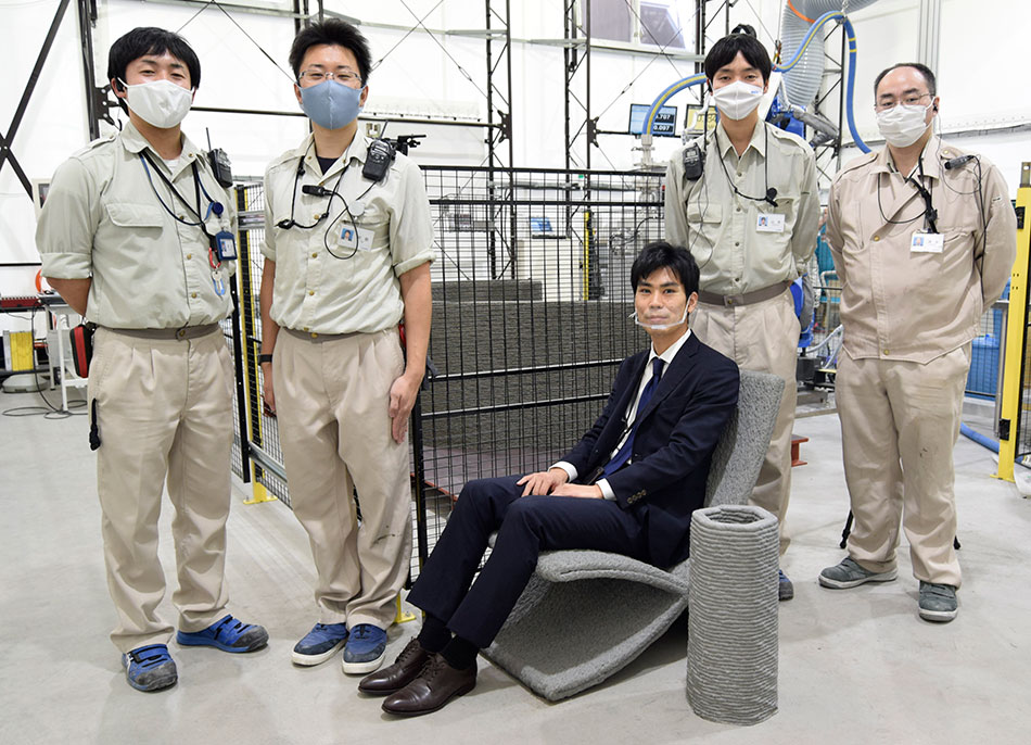 清水建設 技術研究所 社会システム技術センター 主任研究員 小倉大季(中央、腰掛けているのはラクツムで成形したコンクリートチェア)と開発チームメンバー(左から,同センターの菊地竜,阿部寛之,山本伸也,清水和昭)